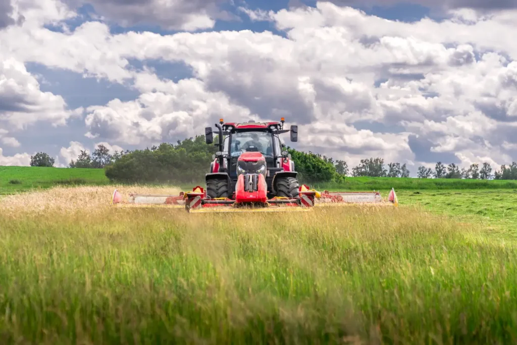 Traktor kosící trávu na poli