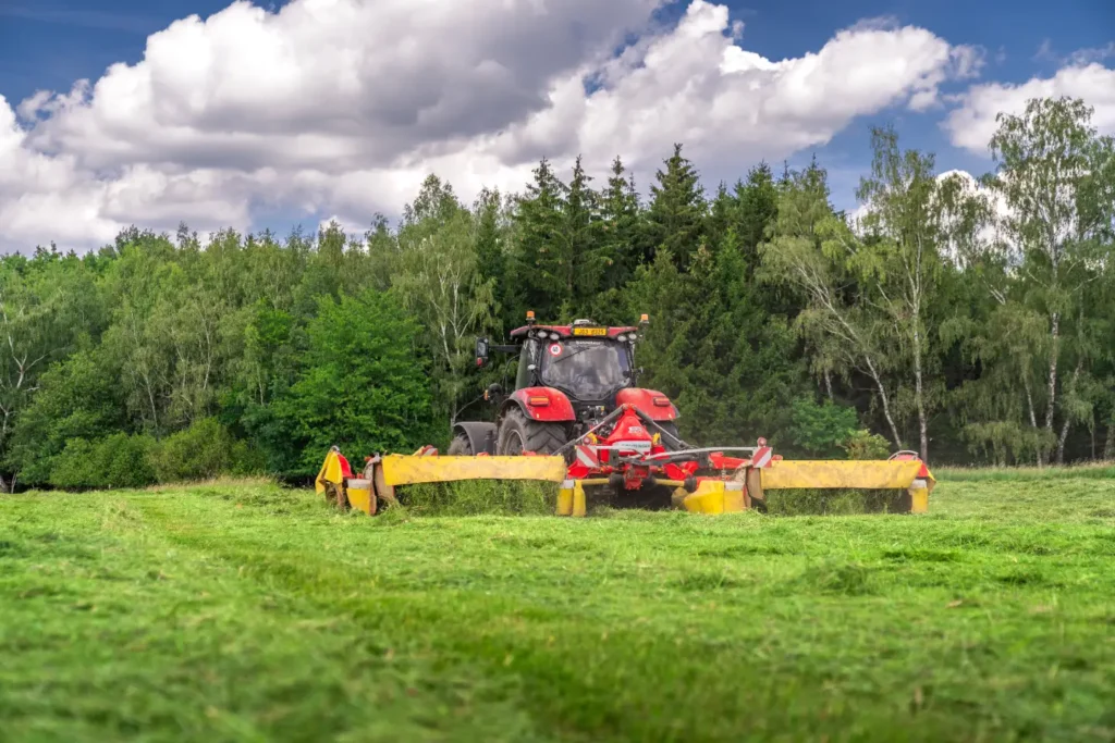Traktor s žací technikou na louce