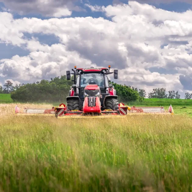 Traktor kosící trávu na poli